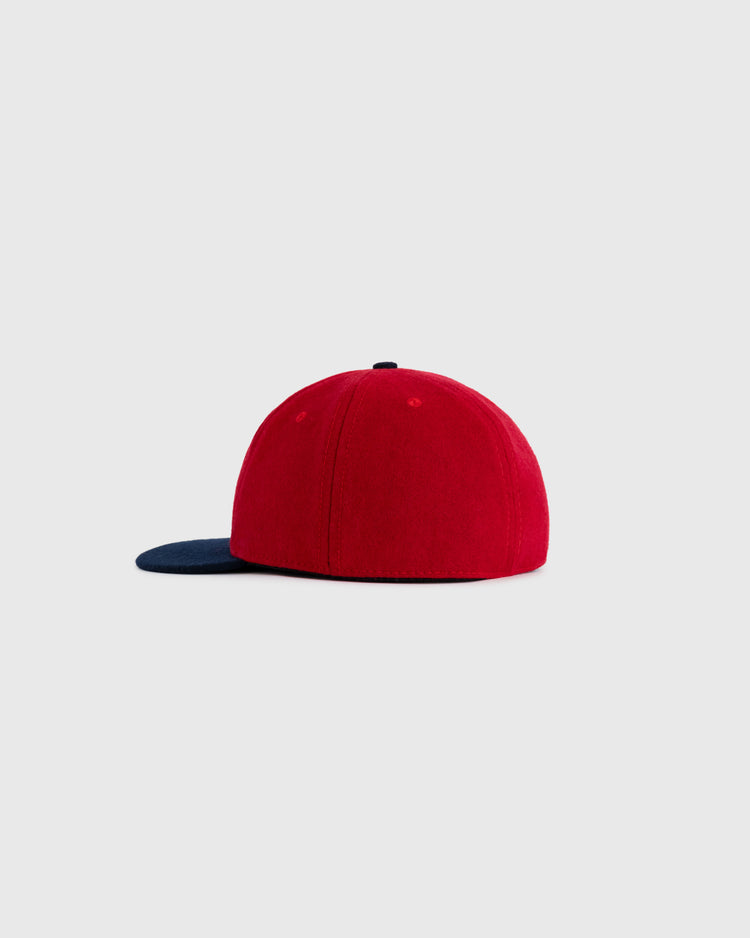 The EFF Kansas City Monarchs 1954 Authentic Wool Ballcap features a red crown and navy blue flat brim, displayed from the side on a plain light gray background.