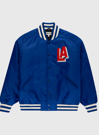 The Ebbets Field Los Angeles Angels (PCL) Satin Varsity Jacket features royal blue satin, white and blue striped cuffs, collar, and hem, snap buttons, and a bold red and white LA chest patch inspired by classic Angels jackets.