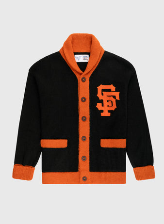 The Ebbets Field Flannels San Francisco Giants 1958-1972 Wool Shawl Collar Sweater features black wool with orange trim, cuffs, and pockets, large orange buttons, a bold SF chest logo, and replicates the classic on-field style.