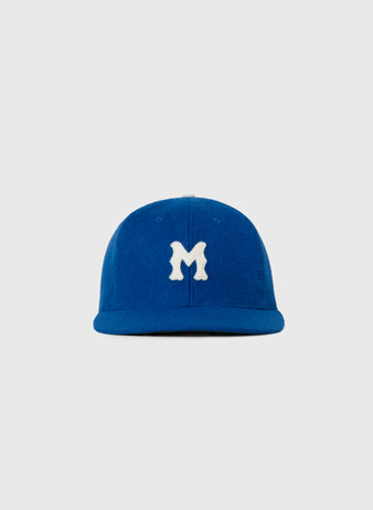 The EFF Montreal Royals 1946 Authentic Wool Ballcap features a blue vintage design with a white stylized M on the front, inspired by the iconic 1946 team hat, displayed against a plain light gray background.