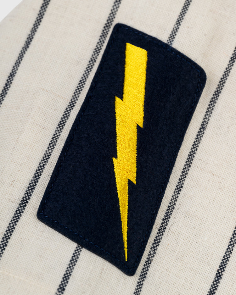 A black rectangular patch with a yellow lightning bolt is sewn onto the cream and black-striped Ebbets Field New York Knights 1939 Authentic Wool Home Baseball Jersey from The Natural.