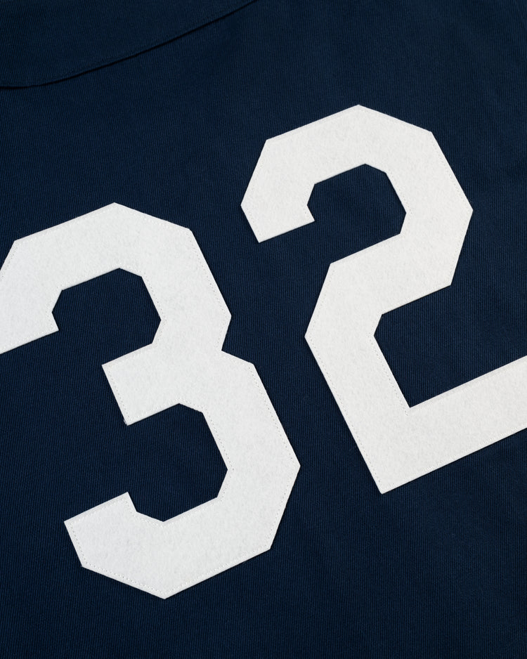 A close-up of the Ebbets Field New York Black Yankees Cotton Twill Baseball Jersey, featuring a bold white number 32 on navy blue, inspired by vintage Negro Leagues style.
