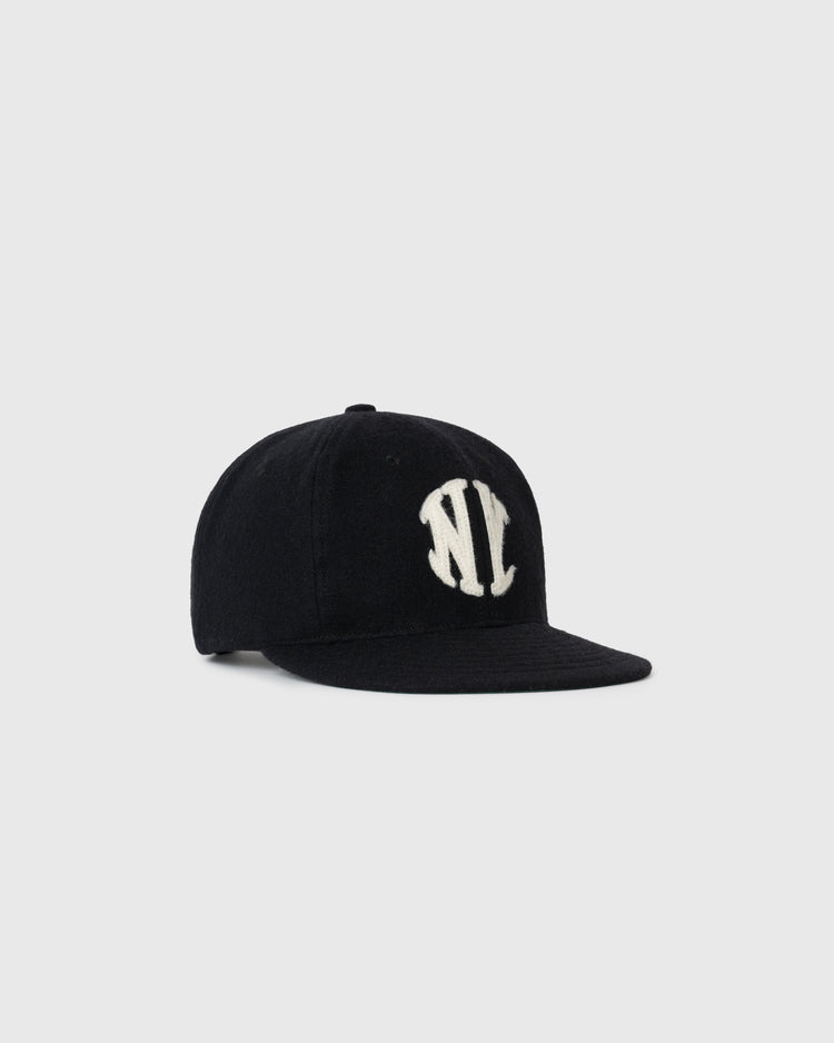 The NEW New York Knickerbockers 1912 Vintage Ballcap by Ebbets Field is a black flat-brim cap with a bold white NY logo embroidered on the front, shown against a plain light gray background.