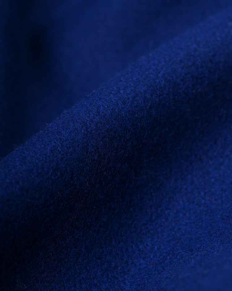Close-up of deep blue, soft wool fabric with subtle folds highlights the smooth surface of the EFF New York Mets 1969 Authentic All Wool Varsity Jacket.