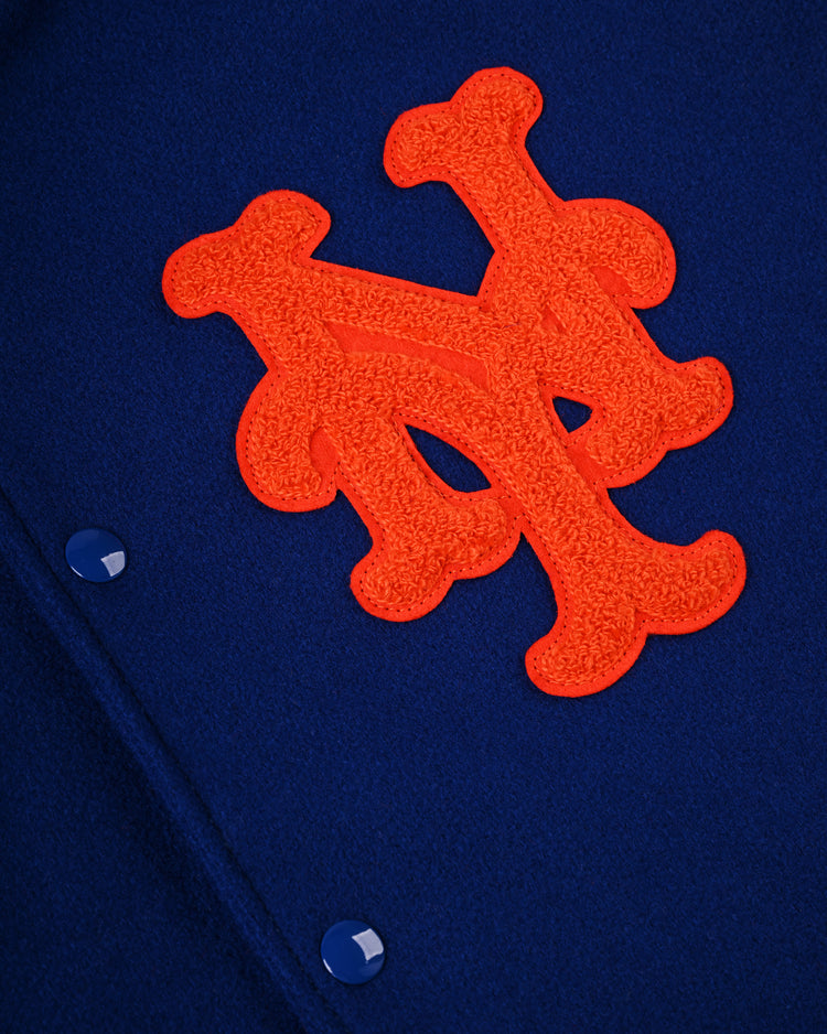 Close-up of the EFF New York Mets 1969 Authentic All Wool Varsity Jacket featuring a blue fabric, orange intertwined NY logo, and blue snap buttons—an authentic recreation of the classic World Series team jacket.