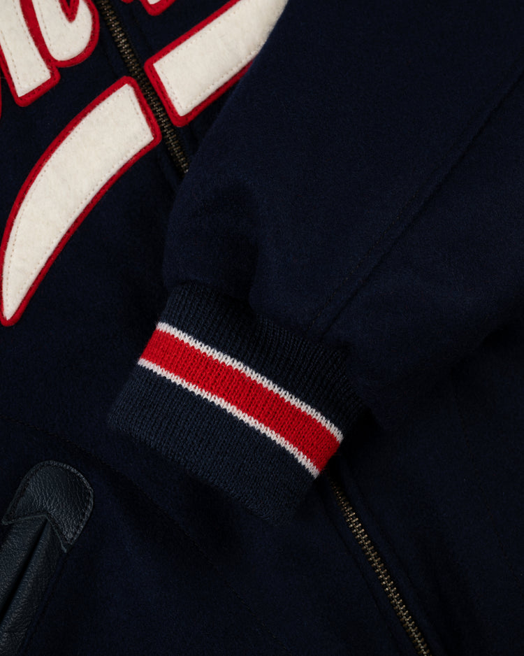 Close-up of an EFF New York Yankees 1947 Authentic All Wool Varsity Jacket sleeve featuring a navy base, red, white, and navy striped cuff, partial embroidered lettering, zipper, and pocket—reminiscent of the teams World Championship era.