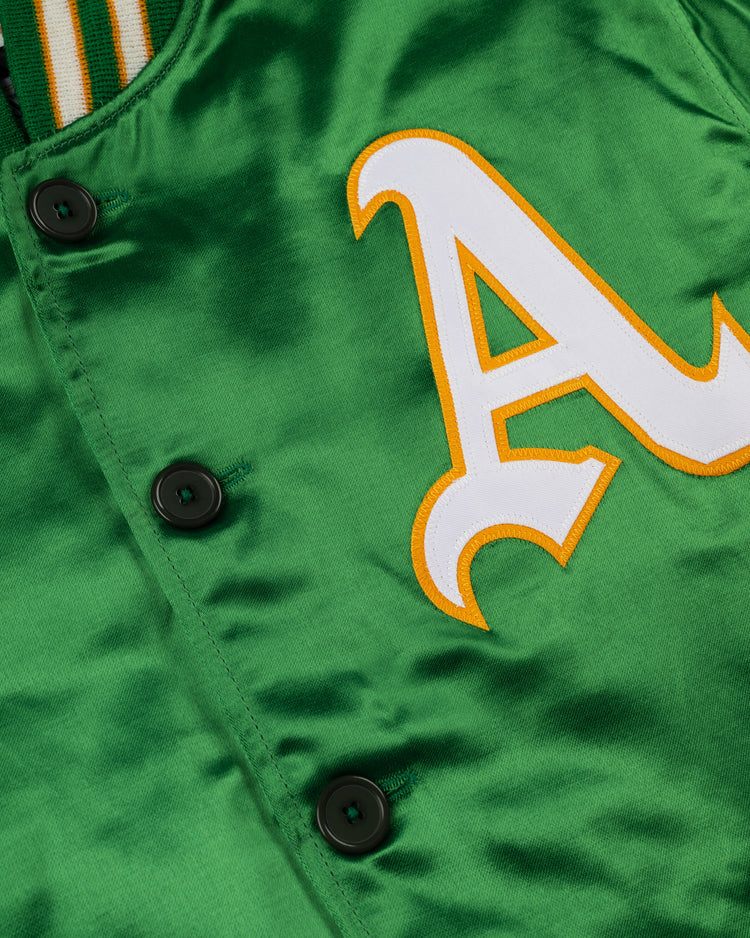 Close-up of the EFF Oakland Athletics 1968 Authentic All Satin Varsity Jacket featuring black buttons, a bold white-outlined yellow A chest patch, and a partially visible green and yellow striped collar.