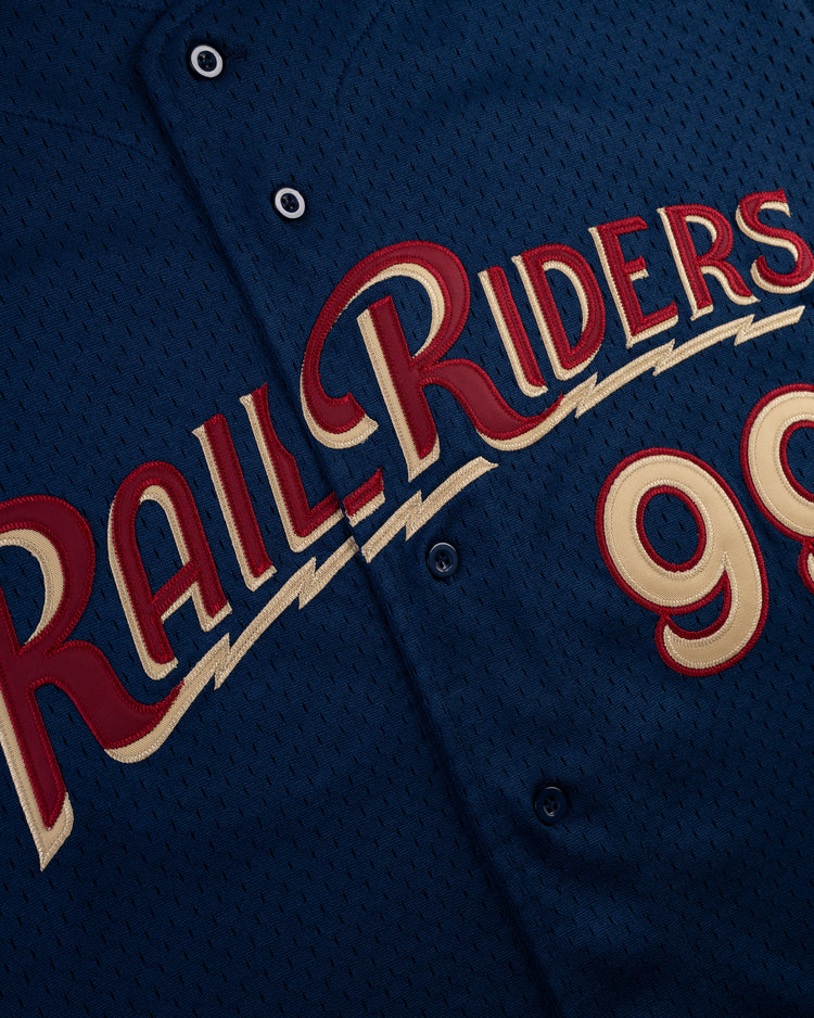 A close-up of the Ebbets Field AARON JUDGE BUTTON UP MESH JERSEY in navy, featuring red and gold RailRiders script lettering and a partially visible number 99.