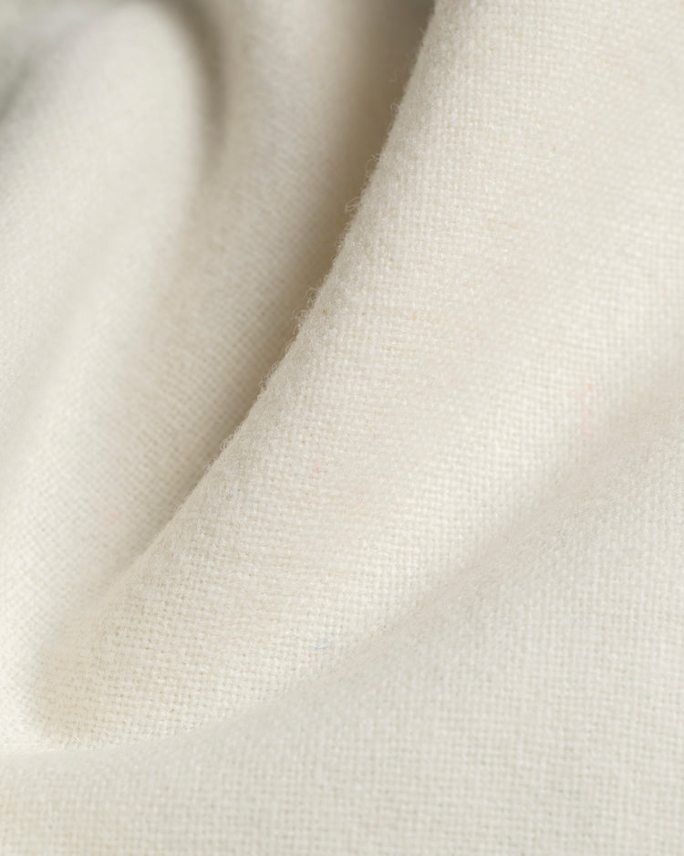 A close-up of soft, off-white wool fabric with a subtle woven texture and smooth folds—an authentic reproduction of the Santurce Cangrejeros 1954 Home Baseball Jersey by Ebbets Field.
