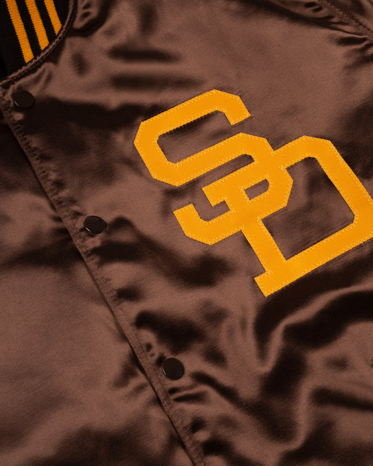 Close-up of the EFF San Diego Padres 1969 Authentic All Satin Varsity Jacket, featuring shiny brown satin, yellow SD embroidery, black snap buttons, and a collar with bold black and yellow stripes for a classic look.