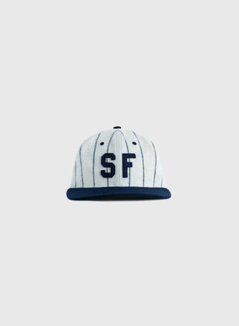 The EFF San Francisco Seals 1946 Authentic Wool Ballcap features a white crown with thin black stripes, a navy brim, and the 1946 SF logo in navy on the front—a true reproduction.