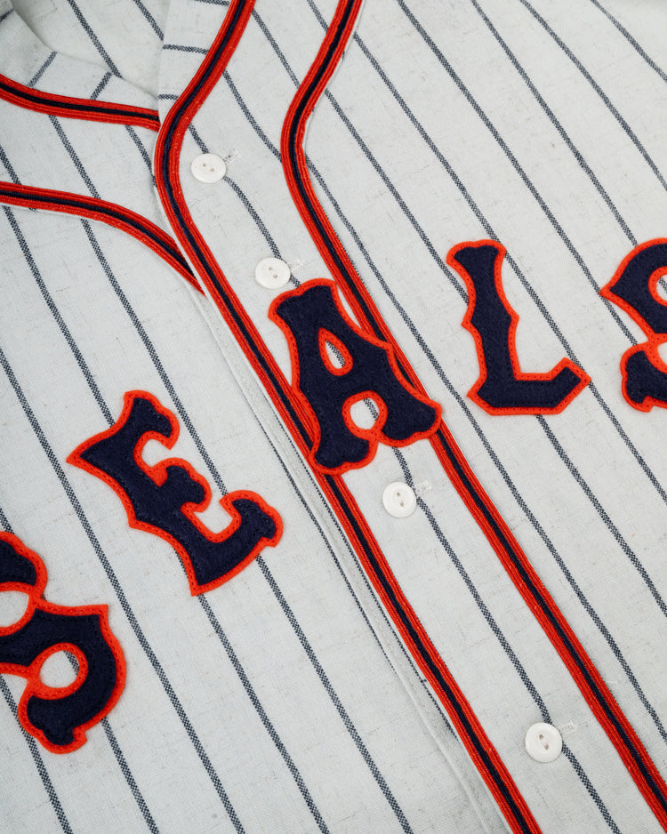 Close-up of the Ebbets Field San Francisco Seals 1938 Authentic Wool Home Baseball Jersey, featuring vintage-style flannel with blue pinstripes, bold red and navy lettering outlined in red, and classic white front buttons.