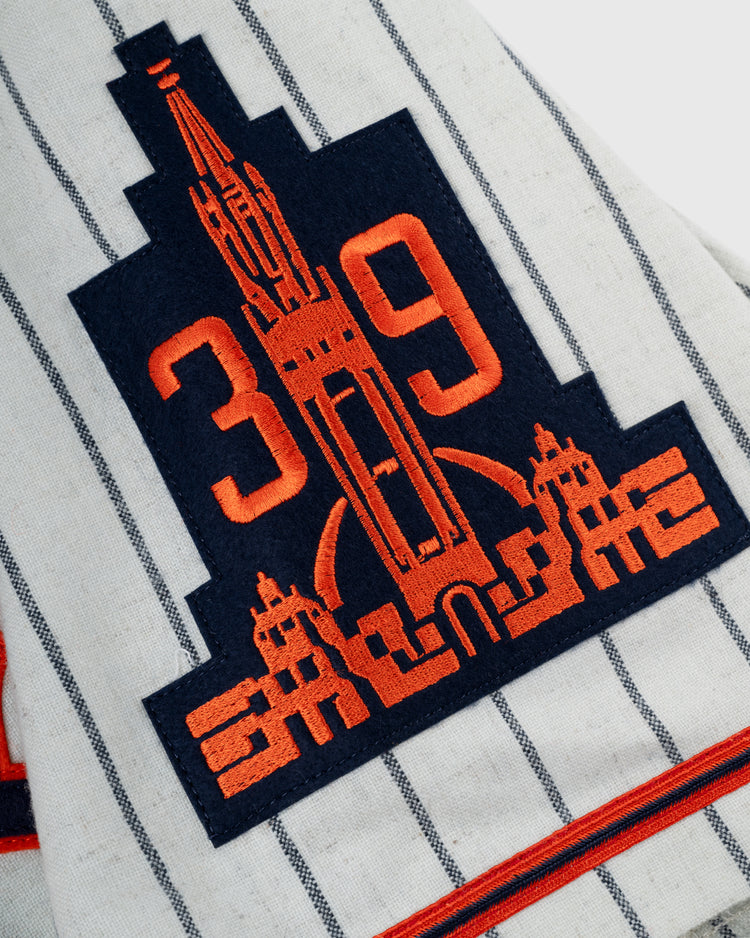 A patch on the Ebbets Field San Francisco Seals 1938 Authentic Wool Home Baseball Jersey features the orange number 39 with a blue and orange embroidered building outline, replicating the original pinstriped flannel design.