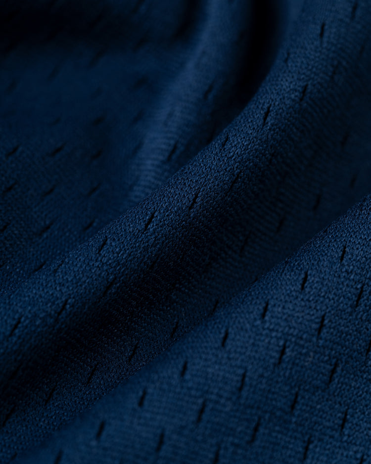 Close-up of dark blue, textured fabric with small, even perforations and soft folds, echoing classic knit patterns from Pacific Coast League days, featured on the EFF San Francisco Seals Cotton French Terry Pullover Hoodie.
