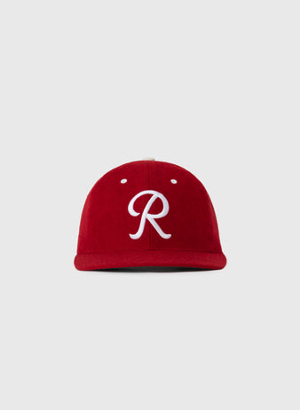 The EFF Seattle Rainiers 1955 Authentic Wool Ballcap features a red design with a white cursive R on the front, shown on a plain light gray background.