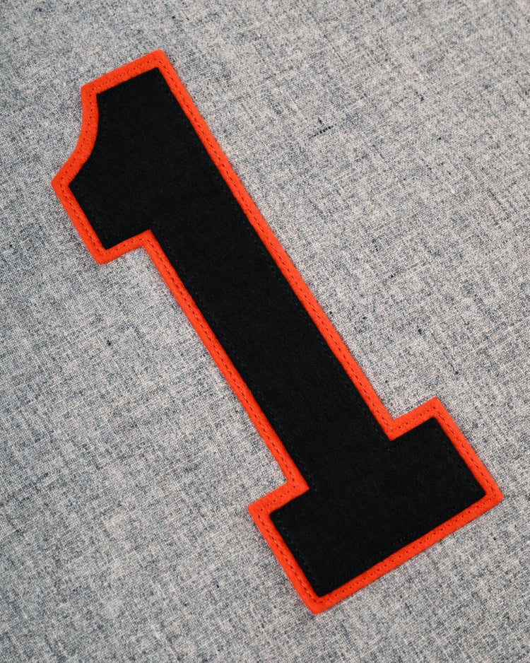 A bold black number one with a red outline is stitched on gray wool, reflecting the classic style of the Tokyo Kyojin (Giants) 1961 Authentic Wool Road Baseball Jersey by Ebbets Field Flannels.