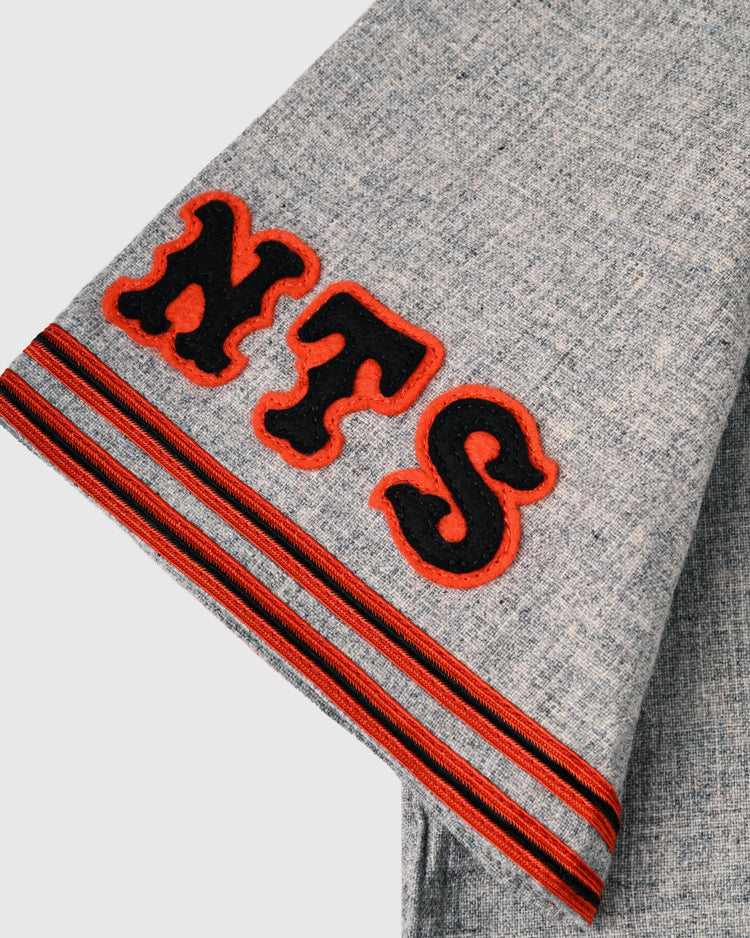 The Tokyo Kyojin (Giants) 1961 Authentic Wool Road Baseball Jersey by Ebbets Field Flannels features gray textured fabric, bold black and orange NTS letters, and red-black striped accents for an authentic replica look.