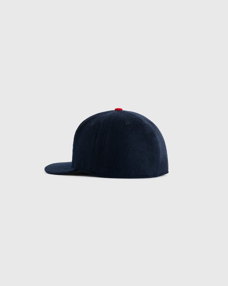The EFF US Tour Of Japan 1934 Authentic Wool Ballcap features navy blue wool, a flat brim, and a red top button, shown from the side against a plain light gray background.