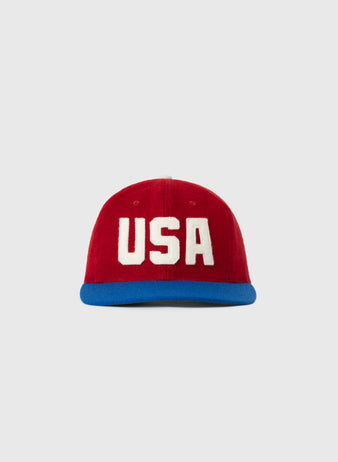 The EFF USA National Team 1956 Authentic Wool Ballcap features a red crown, bold white USA on the front, and a blue brim, shown on a plain light gray background—ideal for fans seeking a classic replica look.