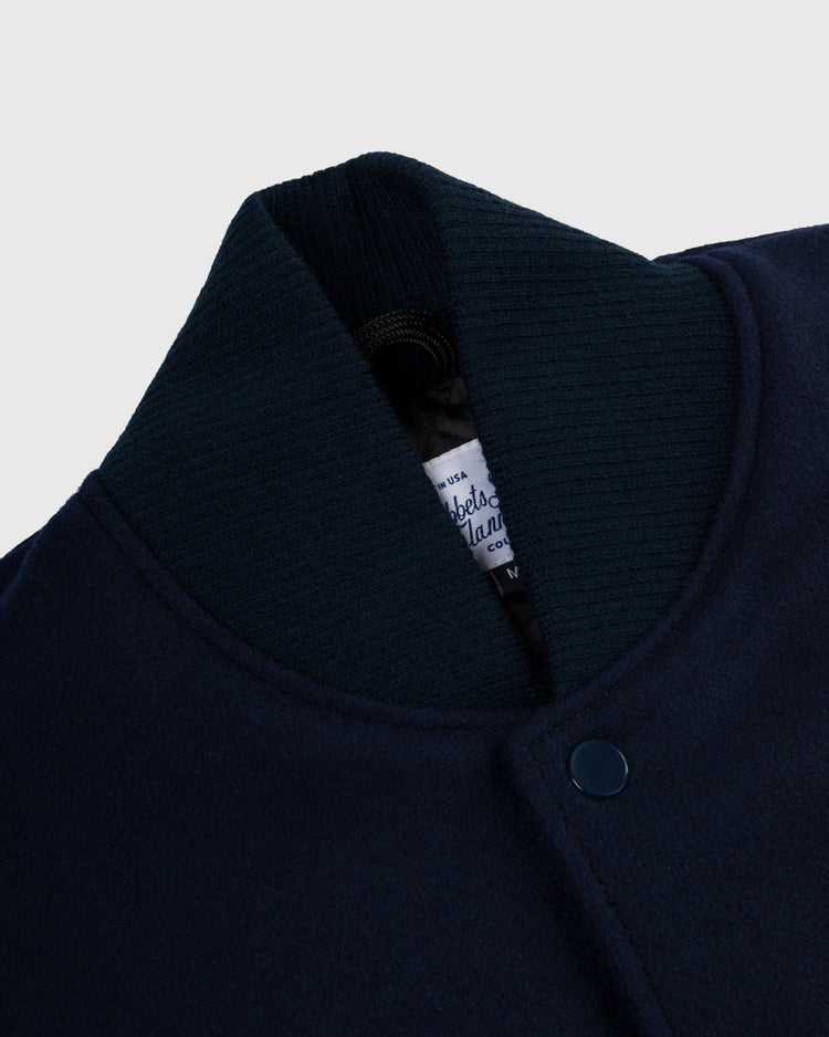 Close-up of the EFF University of Notre Dame Authentic Wool & Leather Varsity Jacket in navy, highlighting the ribbed collar, snap button, and a partially visible white label inside.