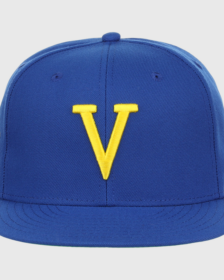 The Vermont Mariners EFF MiLB Vintage Snapback by Ebbets Field Flannels is a blue cap with a yellow V embroidered on the front, featuring an adjustable snapback for comfort and subtle side logos not easily seen from the front.