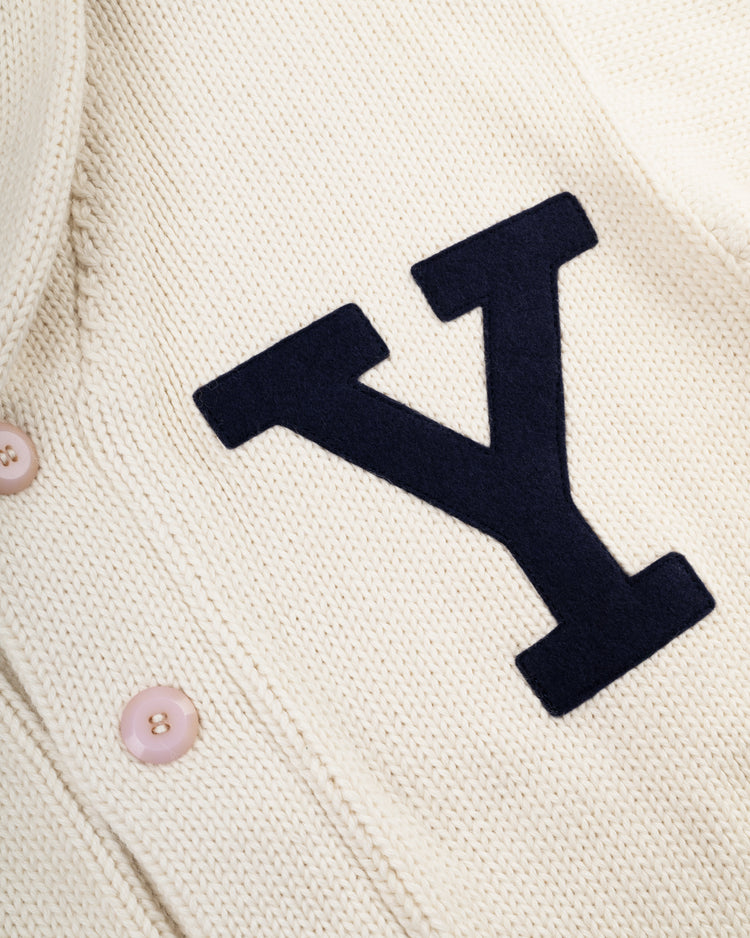 Close-up of the EFF Yale University 1923 Wool Shawl Collar Sweater, featuring a vintage cream knit, pink buttons, and a bold black letter Y patch inspired by classic Yale Football style.