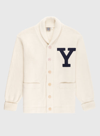 The EFF Yale University 1923 Wool Shawl Collar Sweater features a cream vintage style, long sleeves, two front pockets, five buttons, and a large black “Y” appliqué on the chest, inspired by classic Yale Football varsity knits.