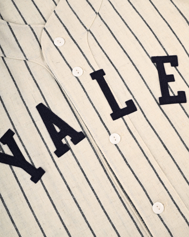 The Yale University 1948 Authentic Wool Home Baseball Jersey by Ebbets Field features a vintage cream flannel design with thin navy pinstripes, bold YALE lettering across the front, and classic white buttons down the center.