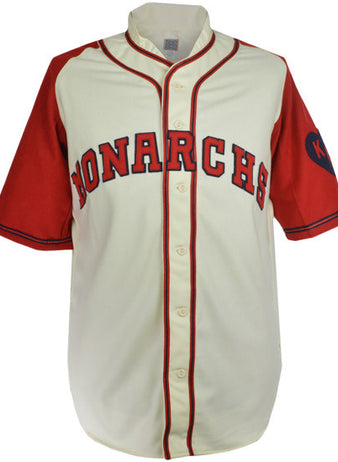 The EFF Kansas City Monarchs 1942 Home Jersey features a cream body, red sleeves, bold red and blue MONARCHS across the chest, and a dark blue KC inside a heart patch on the left sleeve honoring the legendary team.