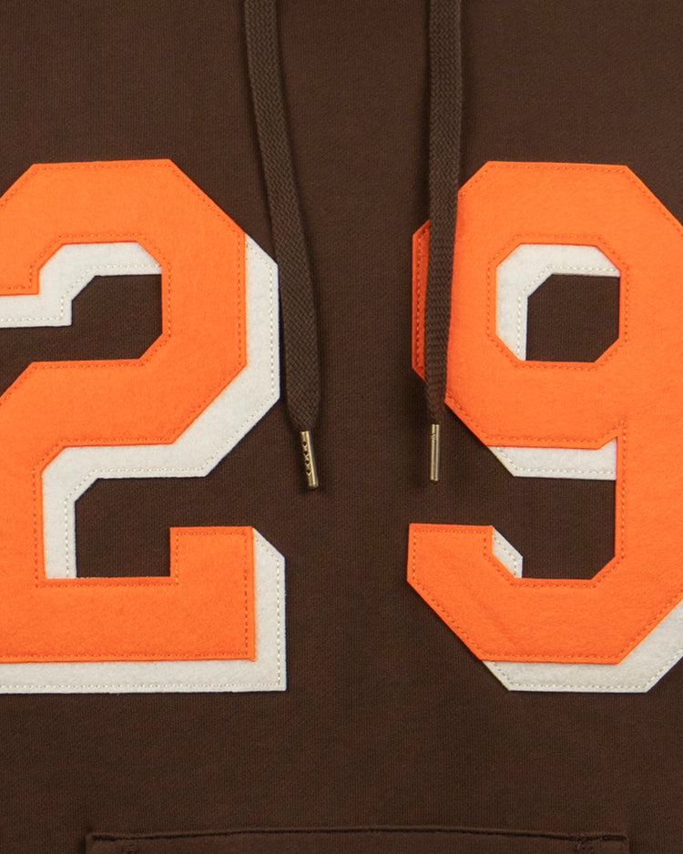 Close-up of the EFF Satchel Paige French Terry Script Hooded Sweatshirt, a brown hoodie with bold orange and white 29 on the front, honoring Satchel Paige’s Negro Leagues legacy and major league debut.