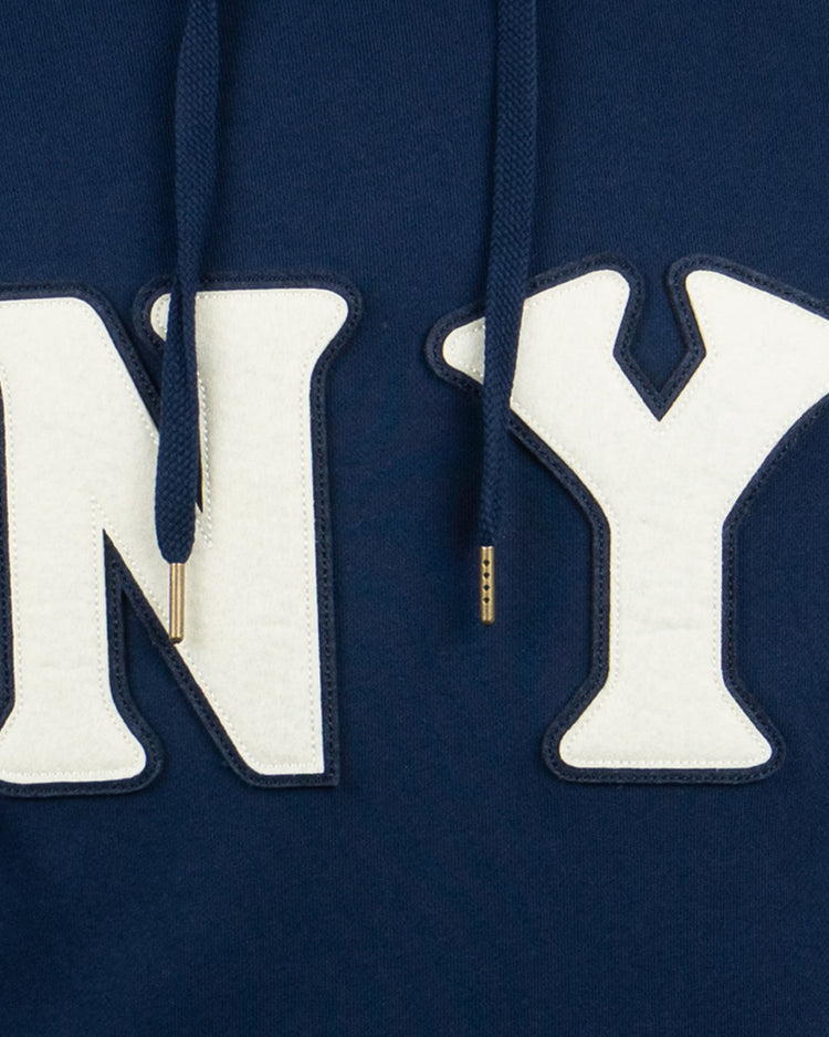 Close-up of the EFF New York Black Yankees French Terry Script Hooded Sweatshirt in navy, featuring bold white stitched NY letters on the front and gold-tipped drawstrings, inspired by the Negro National League team.