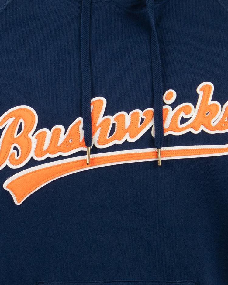 The EFF Brooklyn Bushwicks French Terry Script Hooded Sweatshirt features Bushwicks in orange and white script on navy blue, honoring New York’s legendary semi-pro baseball team.