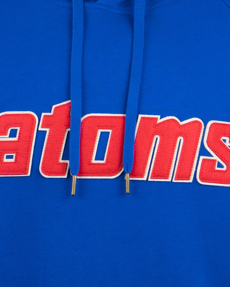 The EFF Sankei Atoms French Terry Script Hooded Sweatshirt features bold red and white “atoms” lettering across the chest, inspired by Atom Boy, with two blue drawstrings with metal tips.