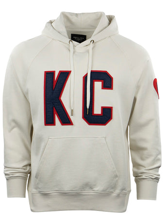 The EFF Kansas City Monarchs French Terry Script Hooded Sweatshirt is cream-colored, with a front pocket, large navy and red KC letters on the chest, and a small red heart on the upper left sleeve.