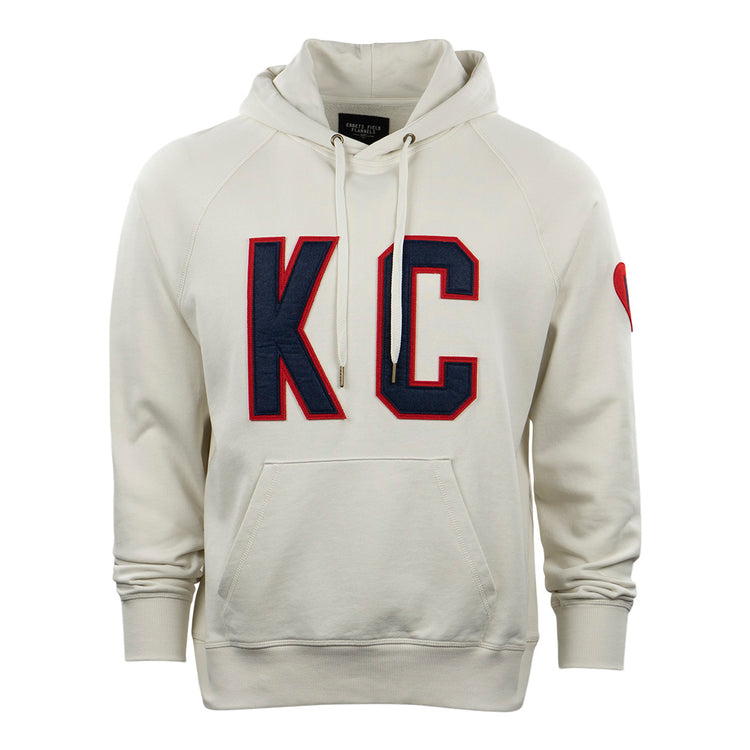 The EFF Kansas City Monarchs French Terry Script Hooded Sweatshirt is cream-colored, with a front pocket, large navy and red KC letters on the chest, and a small red heart on the upper left sleeve.