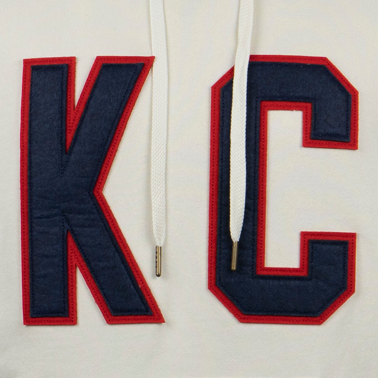 The EFF Kansas City Monarchs French Terry Script Hooded Sweatshirt features large dark blue K and C letters outlined in red, stitched on white fabric with white drawstrings, honoring the Negro Leagues team.