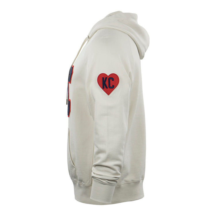 Side view of the EFF Kansas City Monarchs French Terry Script Hooded Sweatshirt in cream, featuring a red heart KC patch on the upper sleeve, front pocket, and drawstrings. Inspired by the historic baseball team.