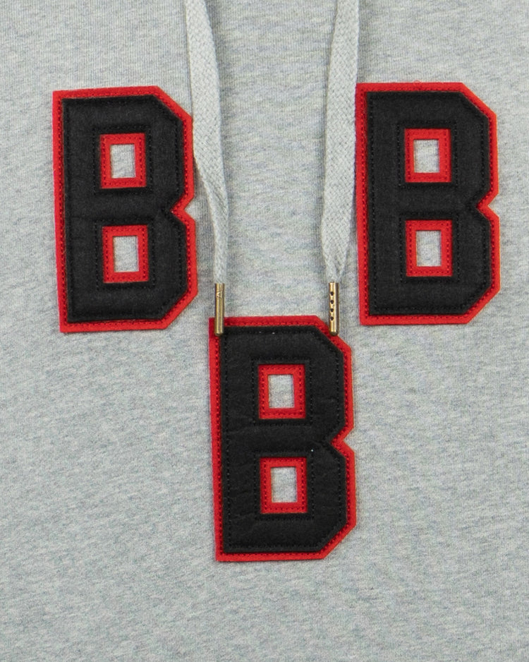 The EFF Birmingham Black Barons French Terry Script Hooded Sweatshirt features three bold black B patches outlined in red—two sewn on and one hanging from the drawstrings—inspired by the Negro National League team.