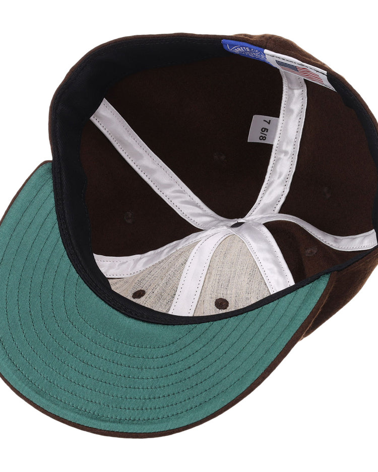 The image shows the inside view of the EFF Salt Lake Bees Vintage Inspired Ballcap in brown, featuring a green brim, white inner seams, blue size tag on the inner band, and a black sweatband with stitched detailing.