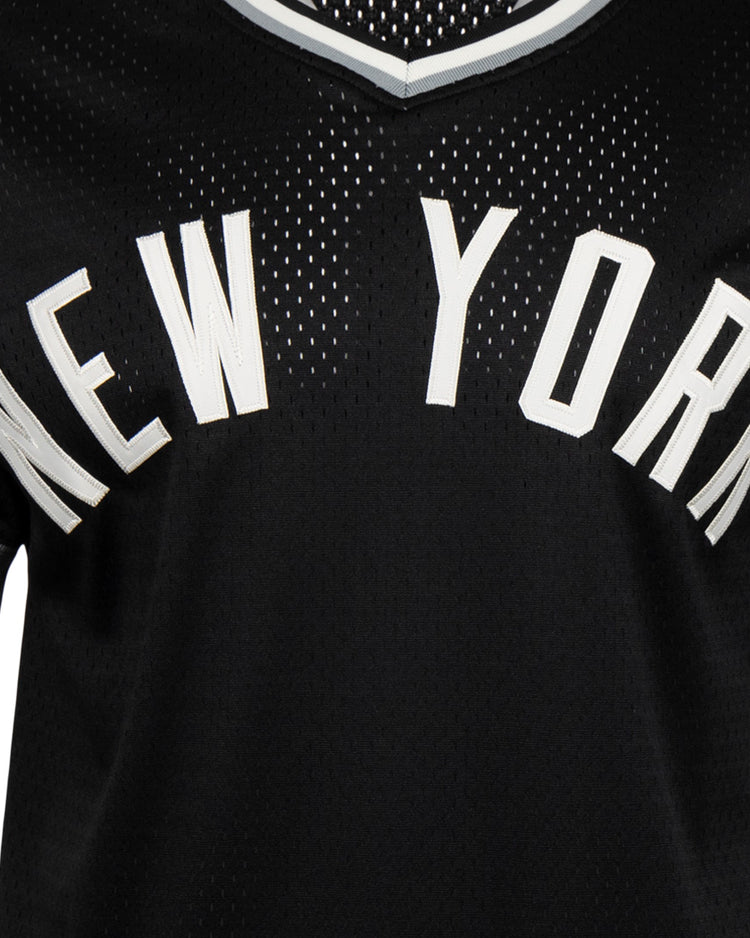 A close-up of the EFF New York Black Yankees Vintage Inspired NL Replica V-Neck Mesh Jersey in black, featuring white trim and bold NEW YORK lettering, capturing classic Negro National League style.