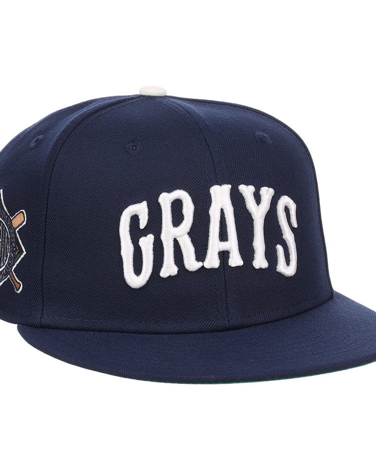 The EFF Homestead Grays NLB Flip Fitted Ballcap is a navy blue cap with GRAYS in bold white letters and a crossed bats “G” emblem, honoring the legendary Pittsburgh Homestead Grays.