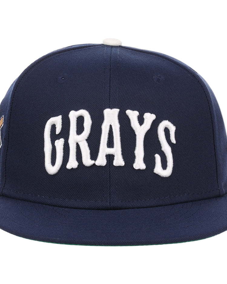 The EFF Homestead Grays NLB Flip Fitted Ballcap is a navy blue cap featuring GRAYS in bold white letters, honoring the legendary Pittsburgh baseball team.