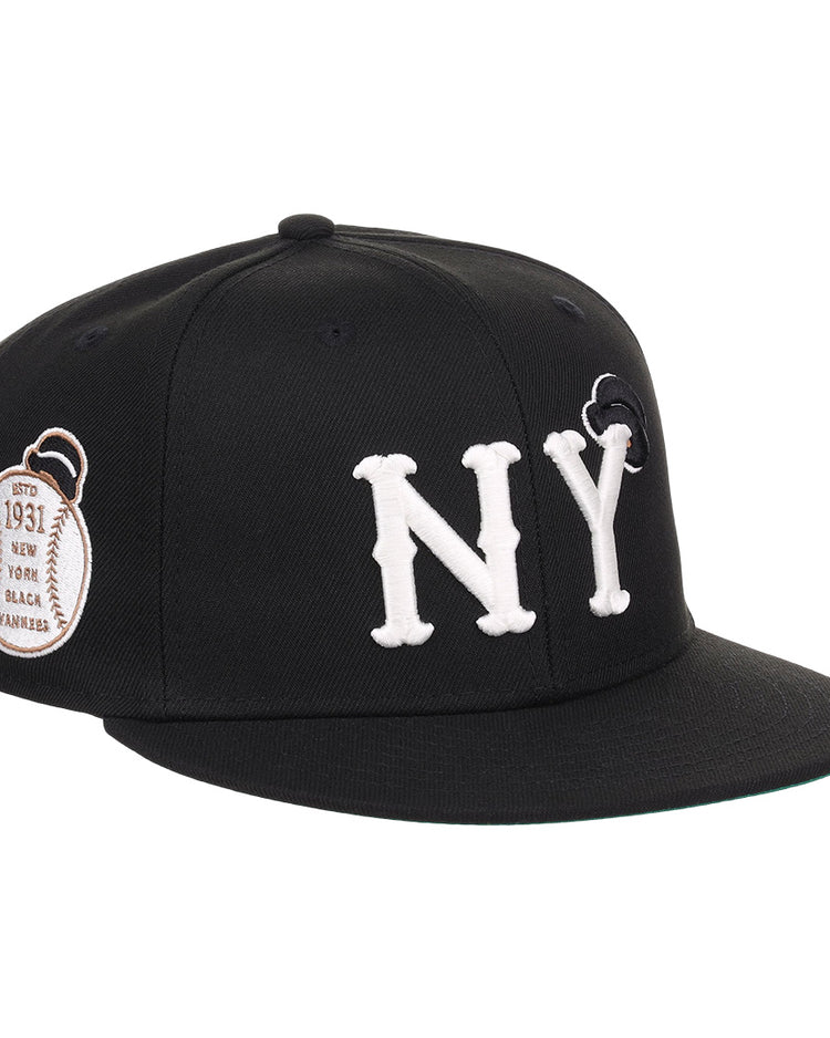 The EFF New York Black Yankees NLB Flip Fitted Ballcap features bold white NY letters, a black design, and a brown 1931 patch on the side honoring Negro National League heritage.