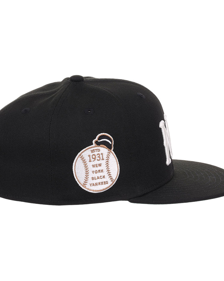 The EFF New York Black Yankees NLB Flip Fitted Ballcap is black with a white NY logo, a baseball patch reading Est. 1931, and New York Black Yankees embroidered on the side to honor the Negro National League. Flat brim design.