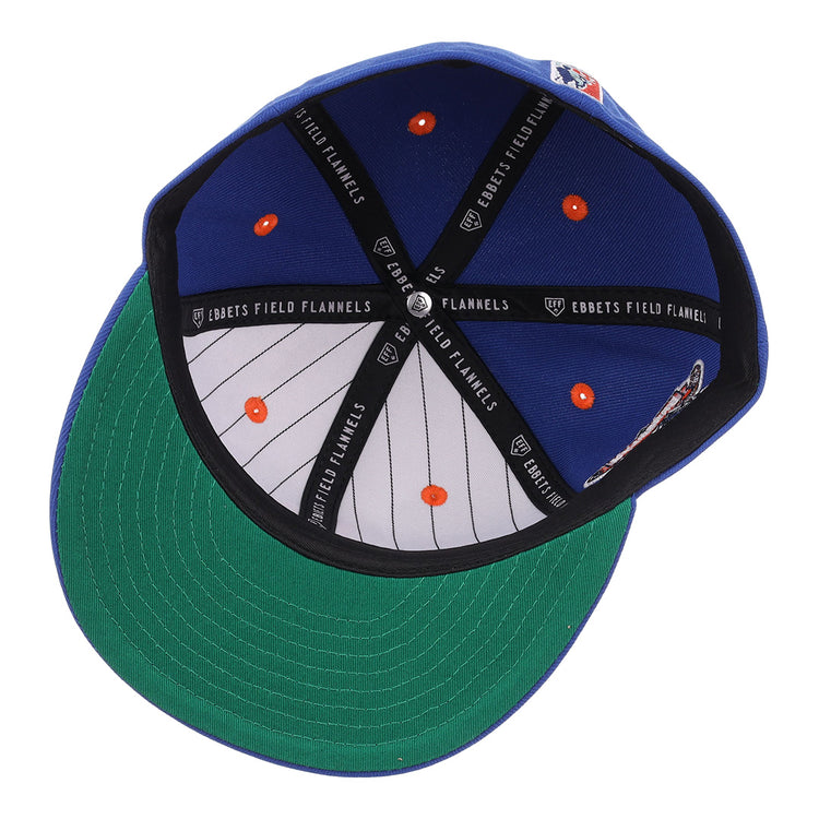 The Brooklyn Royal Giants NLB Flip Fitted Ballcap by EFF features a royal blue design, green underbrim, striped inner lining with orange dots, black EBBETS FIELD FLANNELS bands, and a vintage-inspired look.