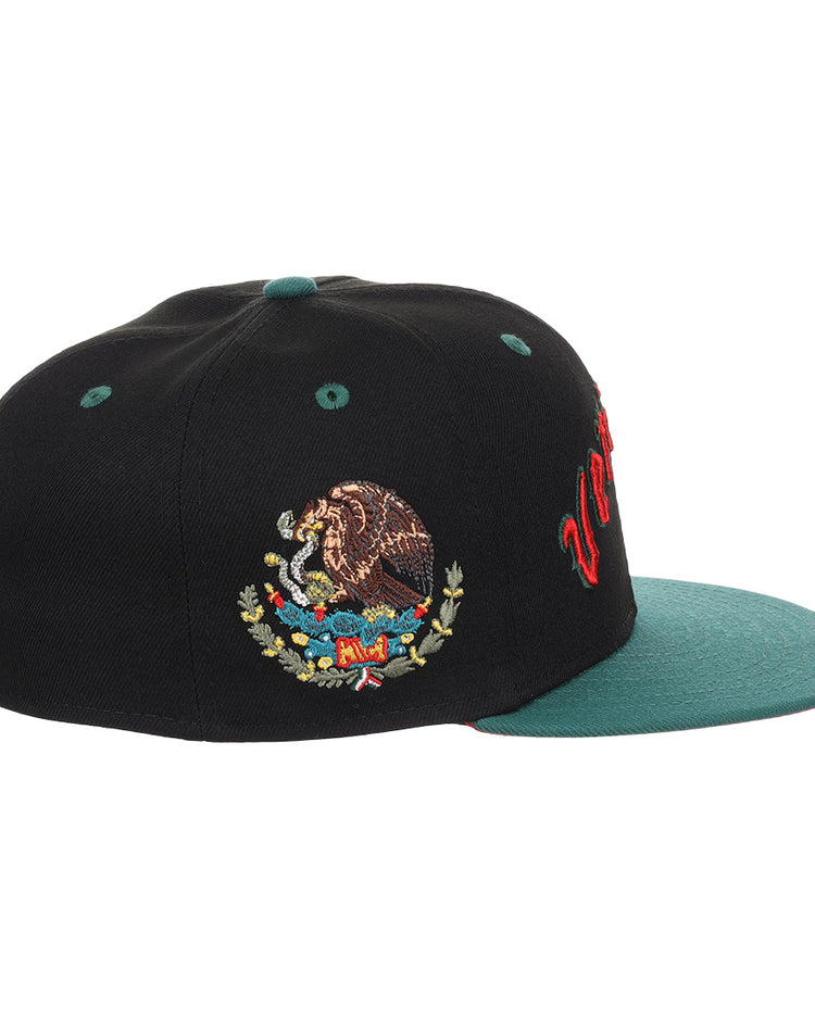 The EFF Veracruz Azules NLB Flip Fitted Ballcap is a black vintage-inspired cap with a green brim, bold red Mexican League lettering on the front, and an embroidered Mexican coat of arms on the side.