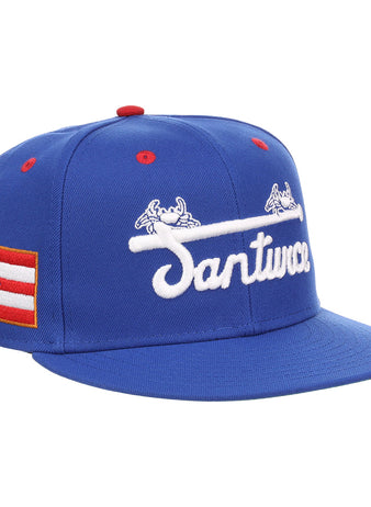 The EFF Santurce Cangrejeros NLB Flip Fitted Ballcap is a blue cap featuring Santurce with a bat and crab, a Puerto Rican flag patch, and honors Puerto Rican League legends like Roberto Clemente.