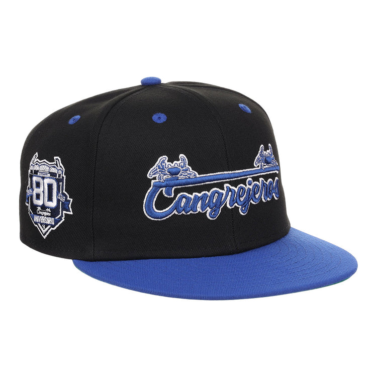 The EFF Santurce Cangrejeros NLB Flip Fitted Ballcap in black features Cangrejeros embroidered in white and blue, the iconic crab logo, and an 80 Aniversario patch—honoring Puerto Rican League heritage.