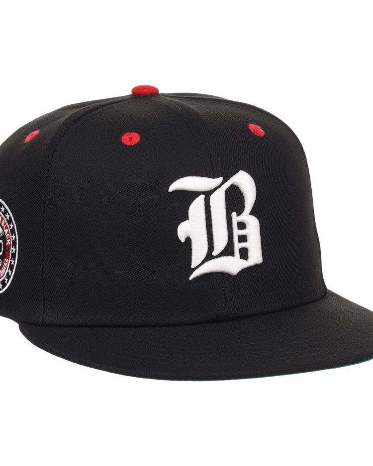 The EFF Birmingham Black Barons NLB Flip Fitted Ballcap is a black cap with a white gothic B, red top button and eyelets, plus a circular patch honoring the Negro National League and Birmingham Black Barons, featuring 1920.