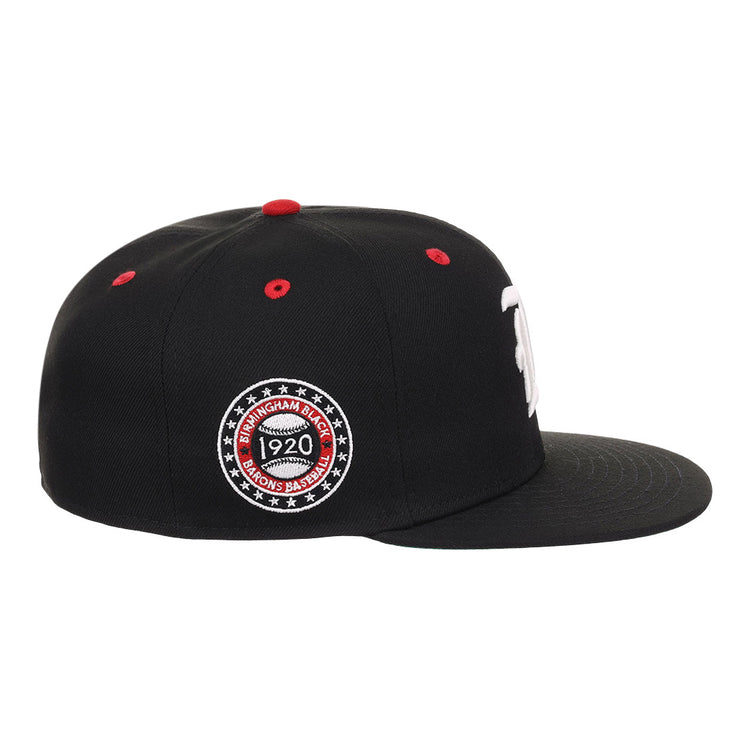 The EFF Birmingham Black Barons NLB Flip Fitted Ballcap is a black hat with a flat brim, red top button, red stitched air holes, and a circular Birmingham Black Barons 1920 patch honoring the Negro National League.